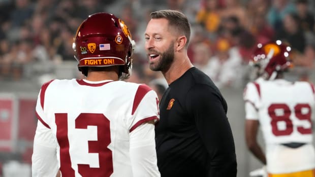 The former Arizona Cardinals head coach and now USC Trojans assistant coach Kliff Kingsbury talks to quarterback Caleb Williams (13) during the pregame warmup before playing the Arizona State Sun Devils at Mountain America Stadium in Tempe on Sept. 23, 2023.